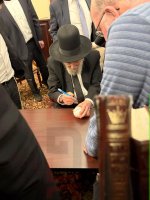 ה_מרן_הגרמה_הירש_חותם_על_כדור_של_תורם_בשיקגו.jpg